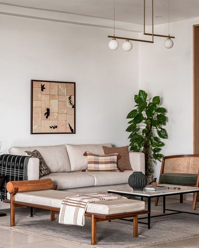 Neutral living room with beige sofa, wooden daybed, cane chair and marble coffee table