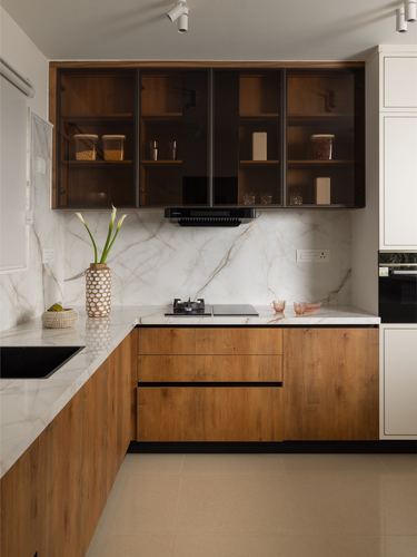 L-shaped kitchen with wood base cabinets, marble-look backsplash, and smoked glass upper cabinets