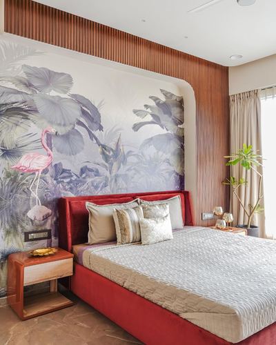 Bedroom with red velvet bed against curved wood-slat wall and flamingo mural