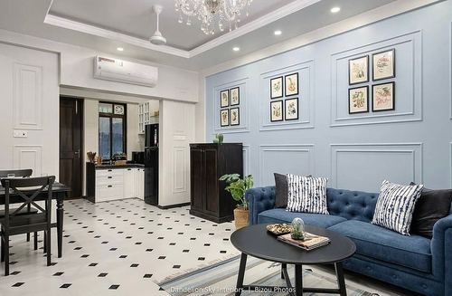 Blue paneled living room with tufted navy sofa and patterned black and white floor