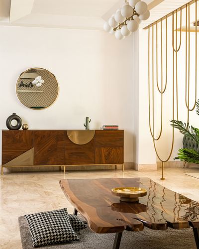Living room with wood sideboard, round mirror, brass chandelier, and live-edge coffee table on marble floor