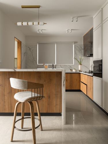 Contemporary kitchen with wood-panelled island, marble backsplash, and cane bar stool