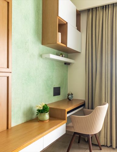 Study nook with green textured wall, floating wood desk, and ribbed beige armchair