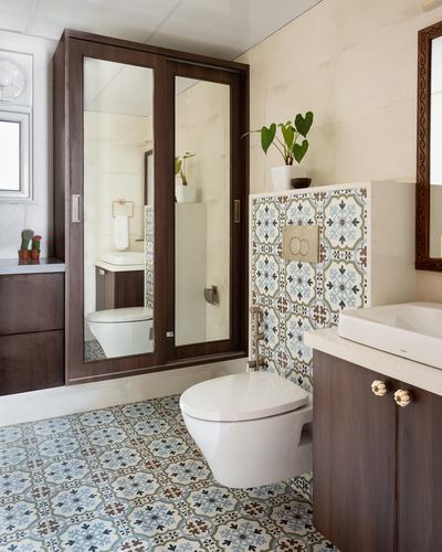Bathroom with mirrored wood cabinet, patterned tile wall and floor, and wall-hung toilet