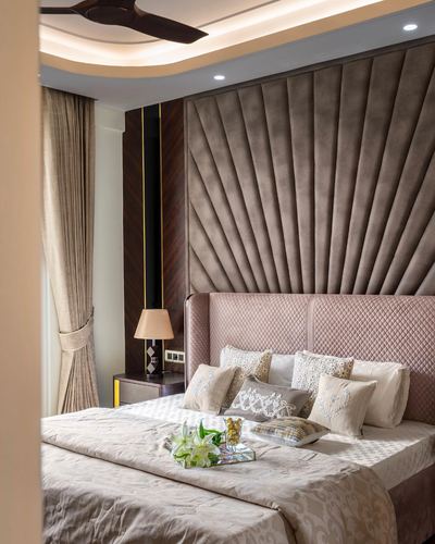 Bedroom with quilted pink headboard and fan-pleated velvet wall panel behind it