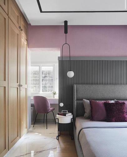 Pink and grey bedroom with fluted headboard wall, wood wardrobe, and sculptural pendant light