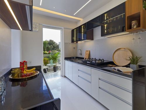 Modern white and black parallel kitchen with balcony view and pendant cove lighting