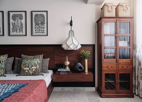 Bedroom with dark wood headboard, floating nightstand, geometric pendant light, and tall glass-front wooden cabinet