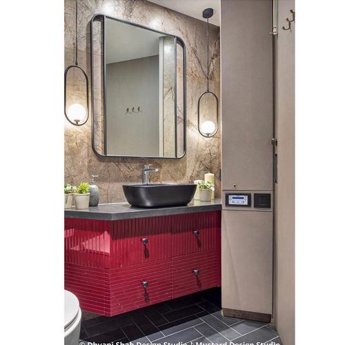 Bathroom vanity with red fluted cabinetry, black vessel sink, arched mirror and stone wall