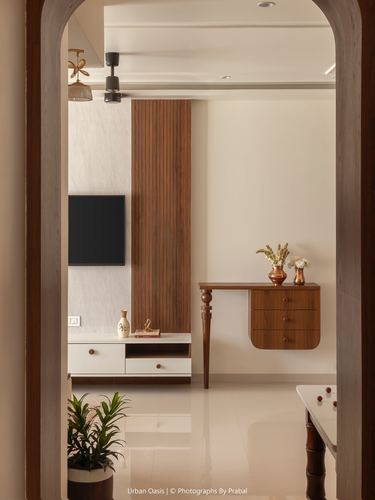 View through arched doorway into living room with fluted wood panel and floating console