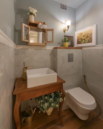 Powder room with wooden vanity, vessel sink, gold fixtures, wall-hung toilet, and sunflower artwork
