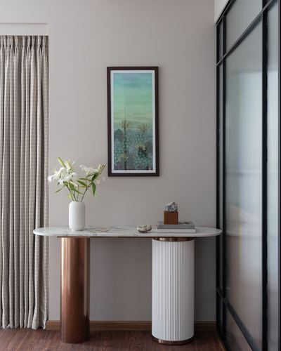 Entryway console with marble top, fluted white and copper legs, framed art above