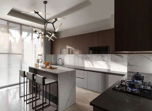 Modern kitchen with marble island, dark wood cabinetry, marble backsplash, and sculptural black pendant light