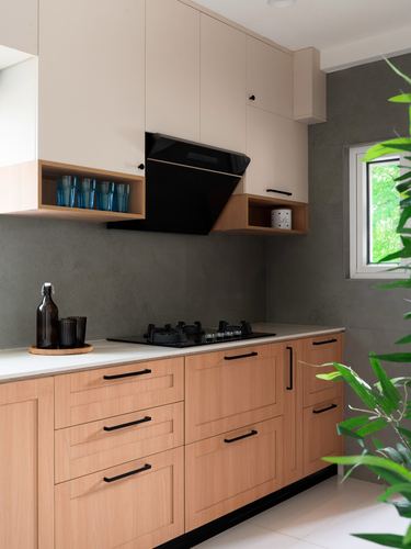 Modern kitchen with wood cabinetry, black chimney hood, white countertop, grey wall and window