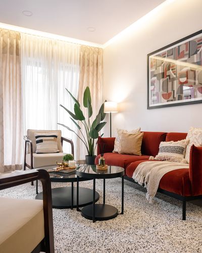 Living room with terracotta velvet sofa, terrazzo floor, sheer curtains, and abstract wall art