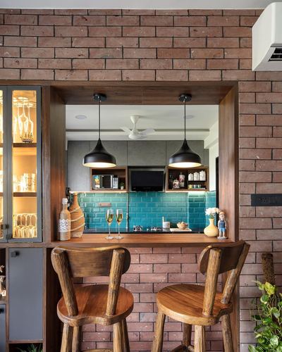 Brick-framed kitchen pass-through with teal tile backsplash and wooden bar stools