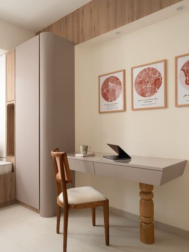 Floating study desk with turned wooden leg beneath framed circular map prints