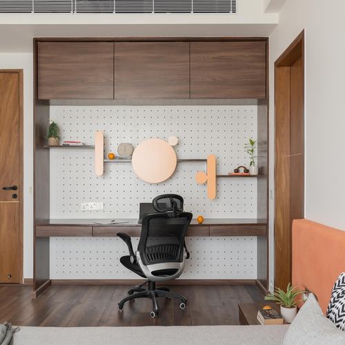 Built-in wooden study nook with pegboard wall, floating shelves, and black office chair
