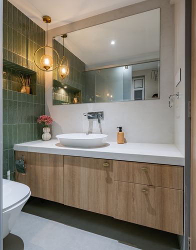 Bathroom vanity with vessel sink, wood cabinetry, green tile wall and round brass pendants
