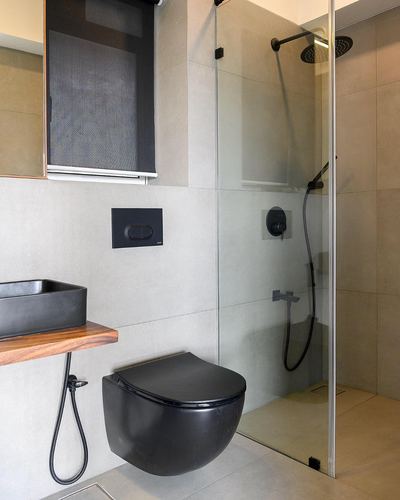 Minimal bathroom with black wall-hung toilet, wood-topped vessel sink, and glass shower enclosure
