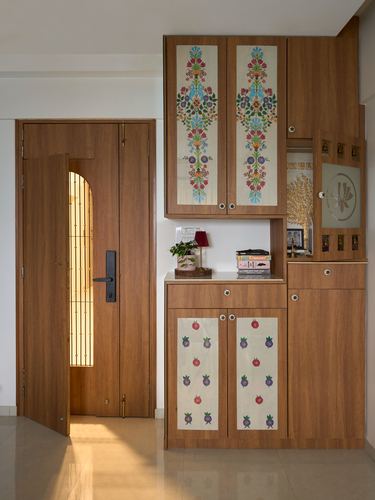 Wooden foyer with arched glass door and storage unit featuring hand-painted floral cabinet panels
