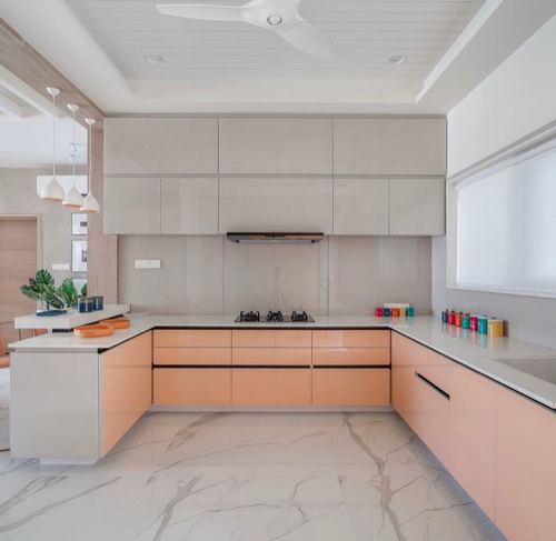 L-shaped modern kitchen with glossy peach lower cabinets, grey uppers, and marble-look flooring