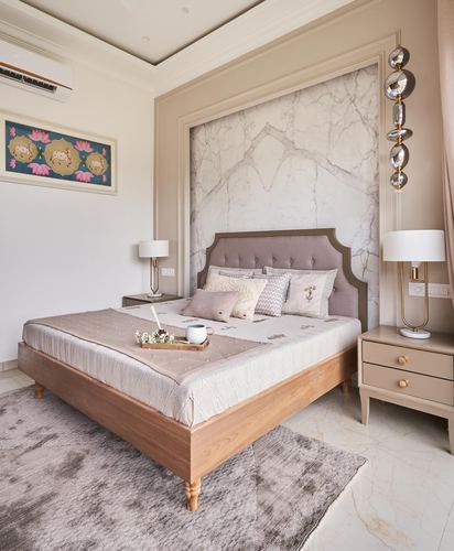 Beige bedroom with tufted headboard, marble-panel wall niche, and wooden bed frame