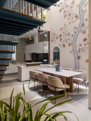 Dining area with boucle chairs under a hand-painted tree mural beside an open kitchen and teal staircase