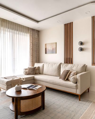 Beige L-shaped sofa with cane coffee table in a neutral toned living room