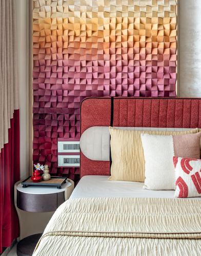 Bedroom with ombre folded-panel wall, ribbed maroon headboard, and layered pillows