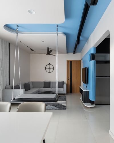 Living room with hanging swing bench, grey sofa, and blue accent ceiling and wall panel