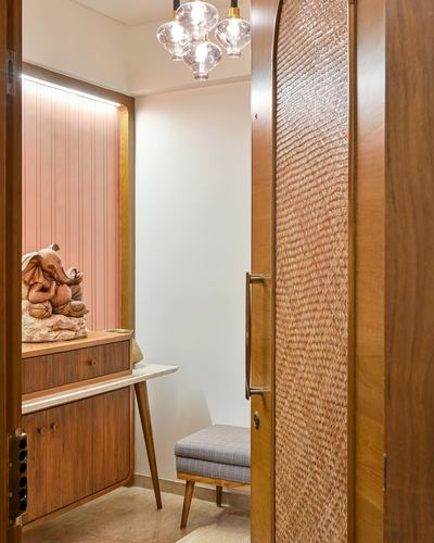 Wooden door with cane weave opens to a foyer with a carved elephant statue on a console