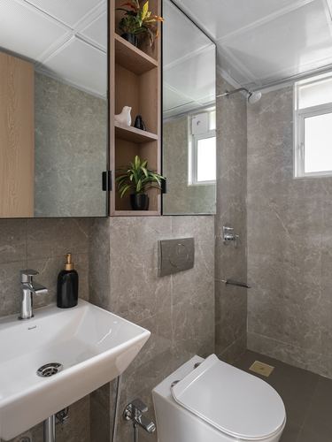 Grey stone-tiled bathroom with mirrored cabinet, wood shelf niche, and wall-hung toilet