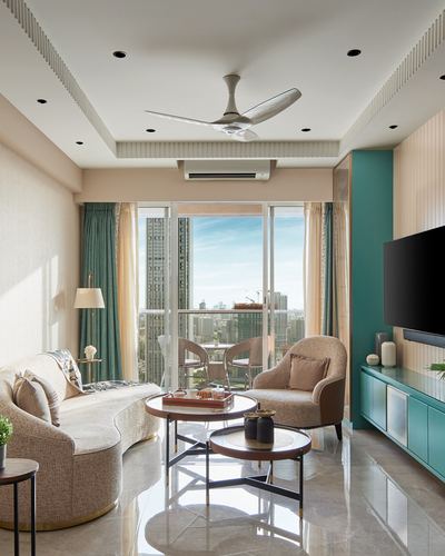 Curved beige sofa and round coffee tables in a sunlit living room with city view balcony