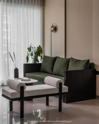 Olive velvet sofa and beige daybed with black frames in a fluted-panel living corner