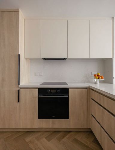 Contemporary kitchen corner with light wood cabinetry, white stone backsplash, and built-in oven