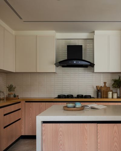 Modern kitchen with pink wood cabinetry, black chimney hood, and ribbed ceramic backsplash