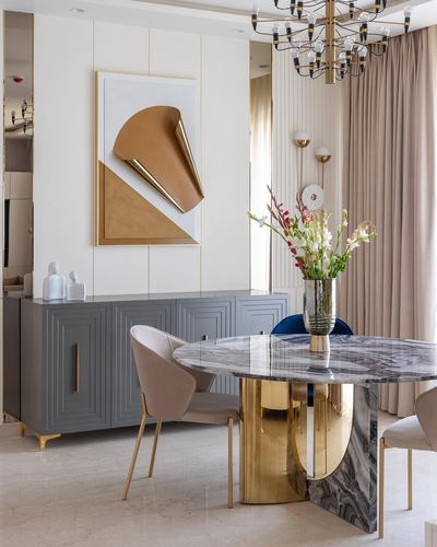 Dining area with round marble table on brass base, grey sideboard, and 3D leather wall art