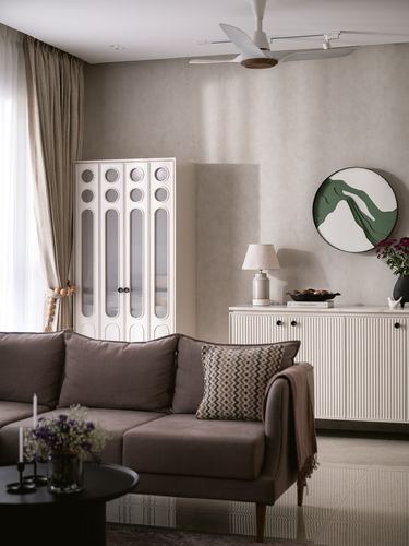 Neutral living room with fluted cabinet, sofa, and round green wall art