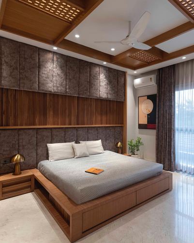 Wooden platform bed against upholstered and ribbed wood headboard wall under coffered wooden ceiling