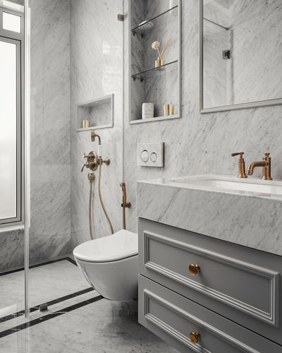 Marble bathroom with brass fixtures, wall-hung toilet, and grey vanity with brass handles