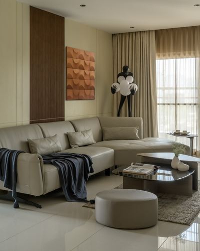 Beige sectional sofa with dark throw in a warm neutral living room with wood accent wall