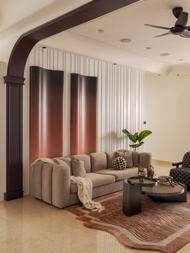 Living room with curved dark arch, fluted wall panels, ombre accent panels, and a beige sofa