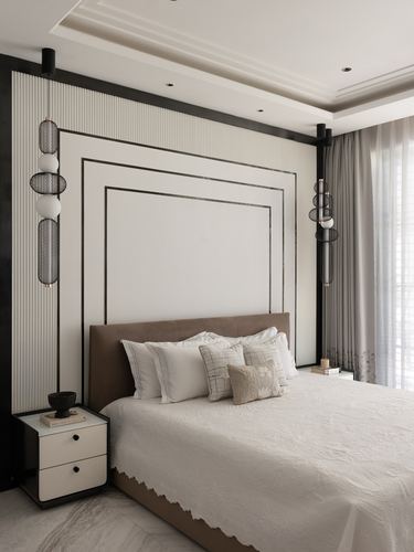 Bedroom with fluted panel headboard wall, black frame outline, and hanging bubble pendant lights either side