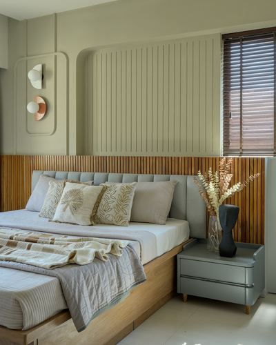 Bedroom with fluted wood panelling, grey tufted headboard, wooden blinds and sculptural bedside decor