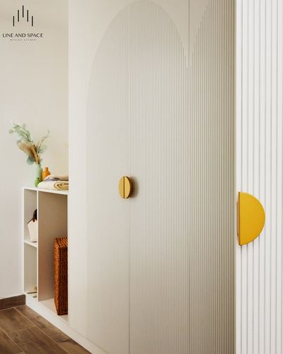 Fluted arched wardrobe doors with half-moon mustard handles beside open shelving with baskets