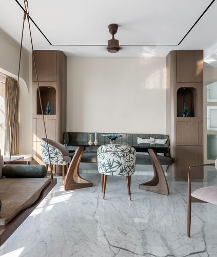 Living room with hanging swing, curved wood bench and floral ottoman on marble floor