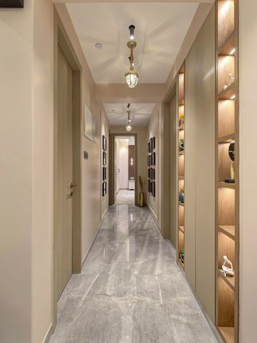 Long hallway with glossy stone floor, brass pendant lights and lit diagonal wood display niches