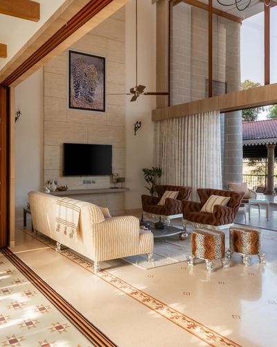 Double-height living room with stone wall, patterned floor, sheer curtains and animal-print seating