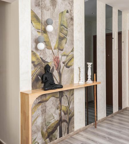 Foyer with banana leaf wallpaper, floating wood shelf, black buddha statue, and mirror strips